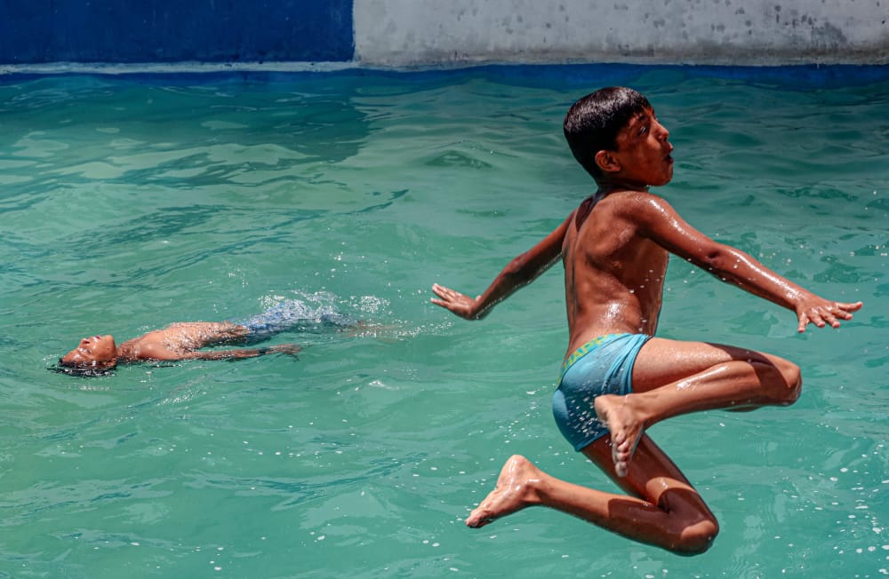 📷أطفال غزة يمارسون هواية السباحة في ظل الأجواء الحارة
