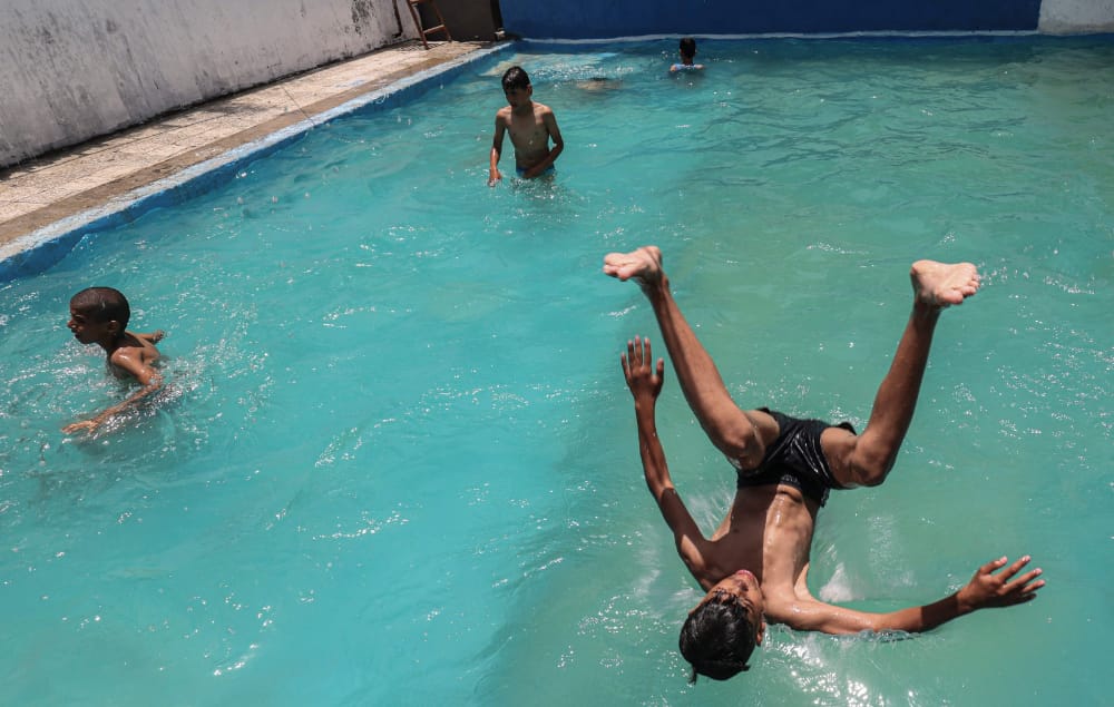 📷أطفال غزة يمارسون هواية السباحة في ظل الأجواء الحارة
