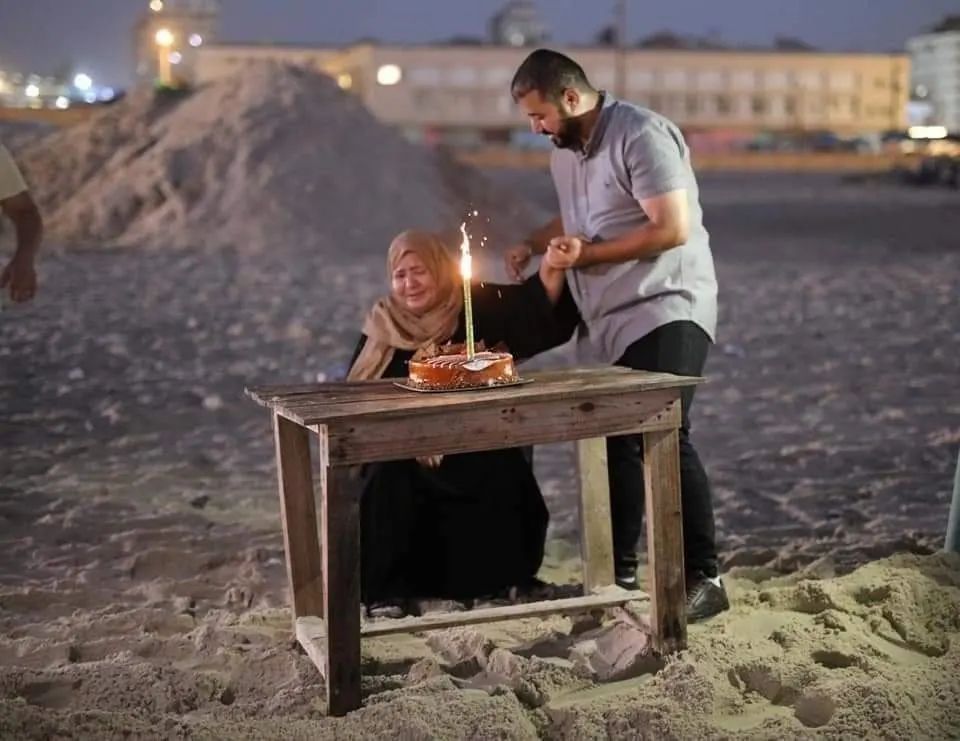 نحت اسم امه على رمال البحر في غزة